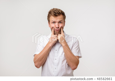 Handsome young man in white shirt trying to smile  48582661