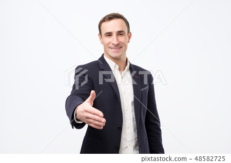 Young man gives handshake, greets with someone 48582725