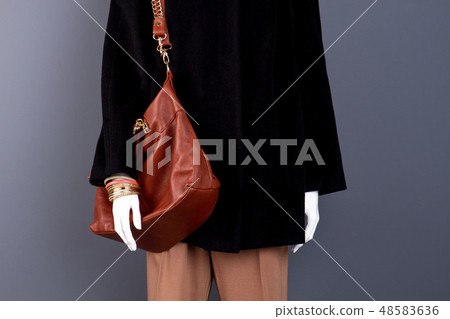 Female mannequin with modern leather bag. Female mannequin with modern leather bag. 48583636