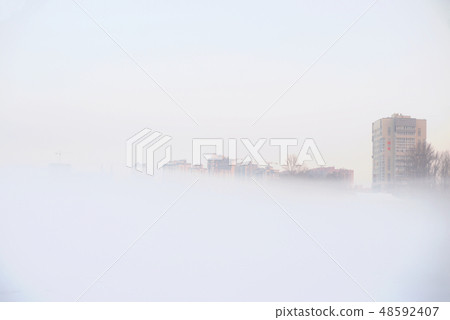 Cityscape with buildings on a foggy winter day. 48592407