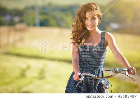 Sexy woman with vintage bike in a country road. 48595497