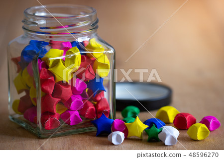 Multicolor paper star in square glass bottle. 48596270