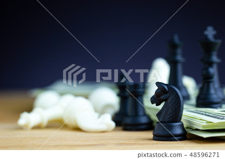 Black chess stands on top of dollar banknotes. Black chess stands on top of dollar banknotes. 48596271