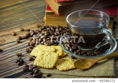 Black coffee in clear glass cup and coffee beans. Black coffee in clear glass cup and coffee beans. 48596272