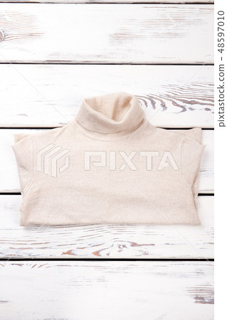 Female warm sweater, wooden background. Female warm sweater, wooden background. 48597010
