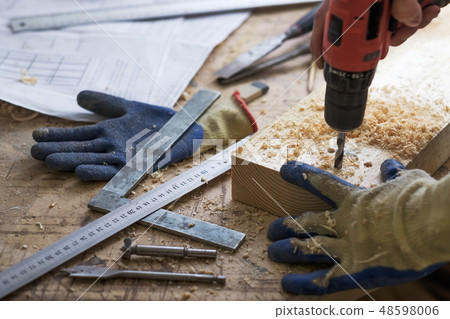 carpenter makes holes with drill in a wooden part carpenter makes holes with drill in a wooden part 48598006