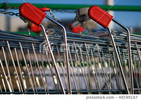 Two shopping carts connected by a chain Two shopping carts connected by a chain 48599187