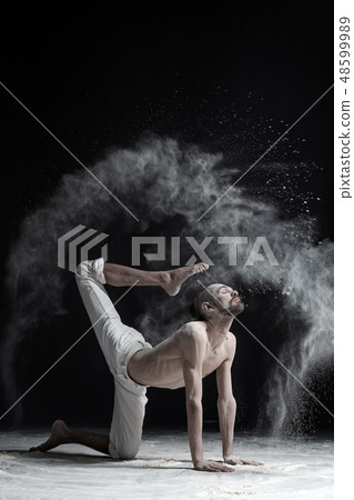 A yoga teacher sits in a sukhasana  48599989