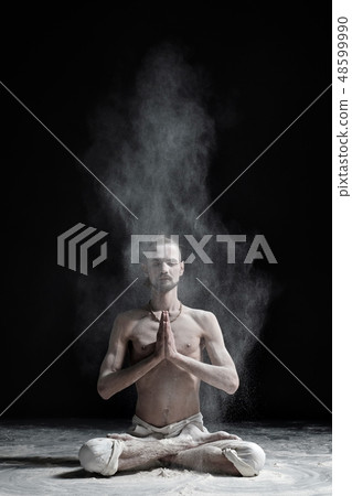 A yoga teacher sits in a sukhasana  48599990