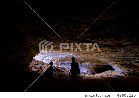 Two unrecognizable tourists at the entrance of Gruta Da Lapa Doce, cave in Iraquara, Chapada 48600229