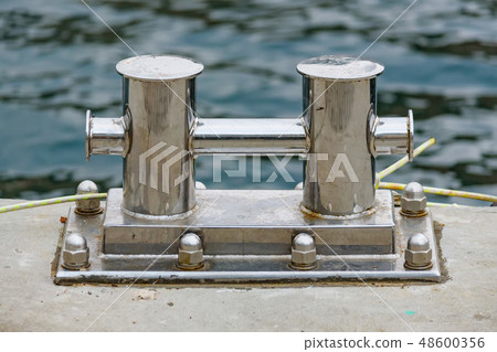 Close up stainless steel bollard or bitts in the dock 48600356