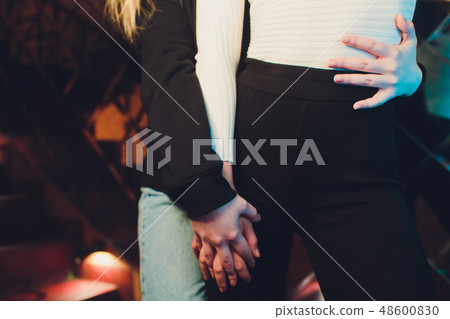 Two girls holding each other hands. Ladies couple the room. Two girls holding each other hands. Ladies couple the room. 48600830