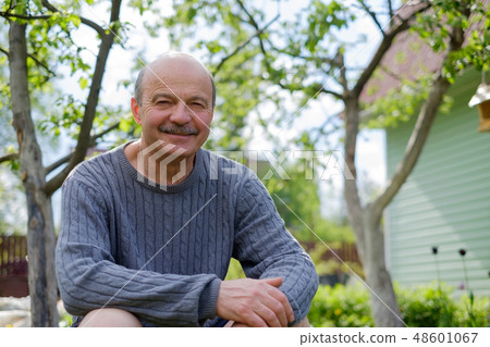 Mature man sitting in countryside Mature man sitting in countryside 48601067