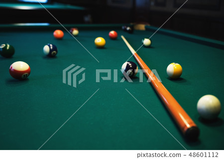 Billiards balls and cue on green billiards table.  48601112