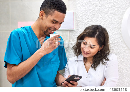 Young african and caucasian dentists on coffee break 48605338