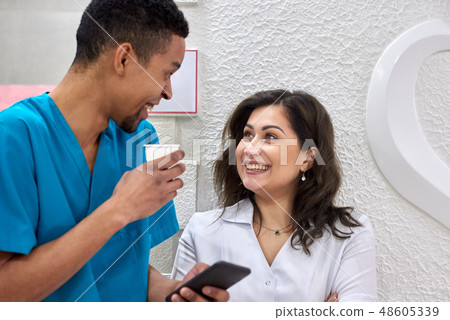 Young african and caucasian dentists on coffee break 48605339