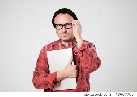 A young programmer holding a laptop A young programmer holding a laptop 48607765