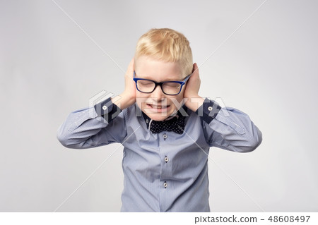 Isolated portrait of gaucasian boy covering ears  48608497