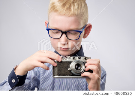 Cheerful smiling child boy holding instant camera Cheerful smiling child boy holding instant camera 48608520