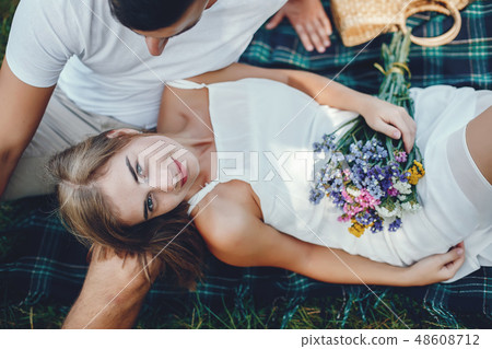 Beautiful couple spend time in a summer park Beautiful couple spend time in a summer park 48608712