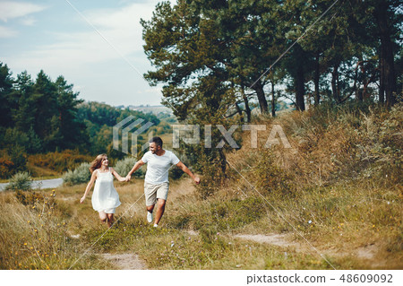 Beautiful couple spend time in a summer park Beautiful couple spend time in a summer park 48609092