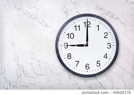 Wall clock show nine o'clock on white marble texture. Office clock show 9pm or 9am 48609176