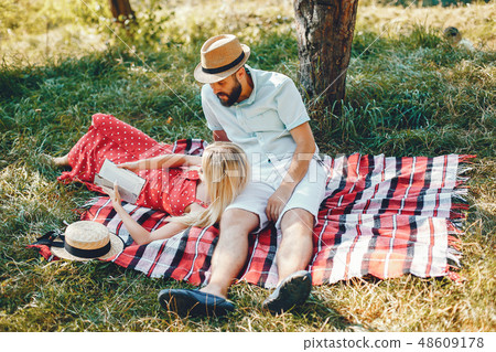 Beautiful couple spend time in a summer park Beautiful couple spend time in a summer park 48609178