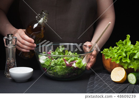 Woman chef in the kitchen preparing salad. 48609239