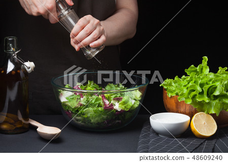 Woman chef in the kitchen preparing salad. 48609240