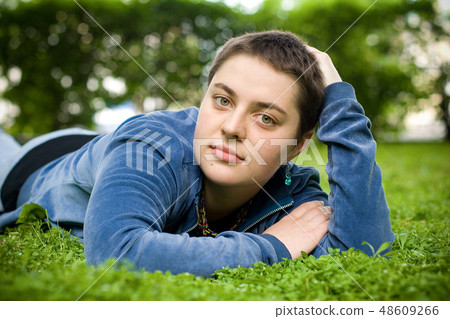 Beautiful girl with short hair on the grass. Beautiful girl with short hair on the grass. 48609266