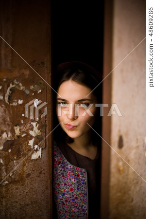 A curious girl looks out from behind the door. A curious girl looks out from behind the door. 48609286