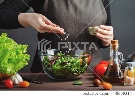 Woman chef in the kitchen preparing salad. 48609314