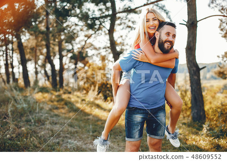 Beautiful couple spend time in a summer park Beautiful couple spend time in a summer park 48609552