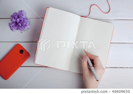 She writes her thoughts in a notebook. 48609650