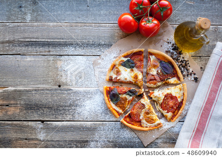 Appetizing pizza margarita on a wooden table. Appetizing pizza margarita on a wooden table. 48609940