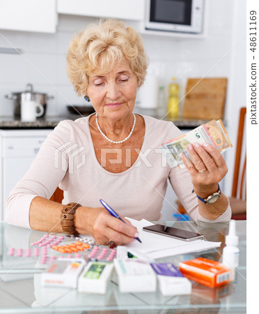 Woman counting her expenditure on pills Woman counting her expenditure on pills 48611169