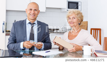 Woman giving money to agent Woman giving money to agent 48611271