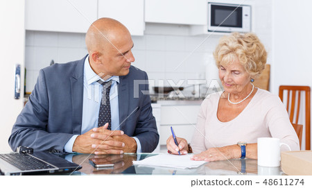Agent helping to elderly woman Agent helping to elderly woman 48611274
