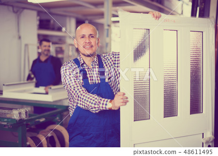 Workers with PVC doors . Workers with PVC doors . 48611495