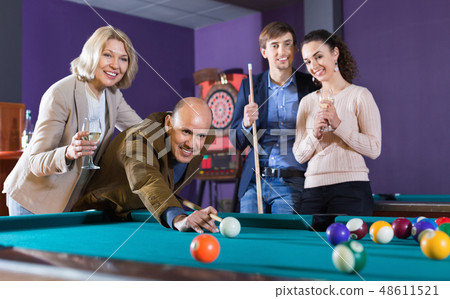 Relaxed people playing billiard and darts as hanging out 48611521