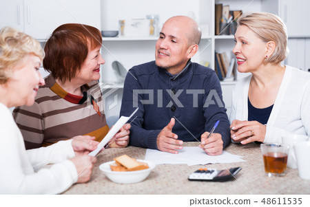 Mature friends are talking about documents Mature friends are talking about documents 48611535