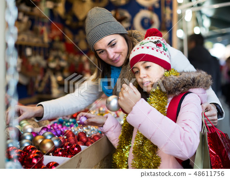 joyous mother with little daughter buying decorations for Xmas joyous mother with little daughter buying decorations for Xmas 48611756