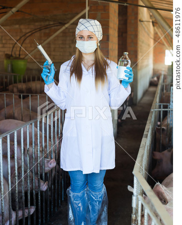 Young happy female veterinarian with syringe Young happy female veterinarian with syringe 48611976
