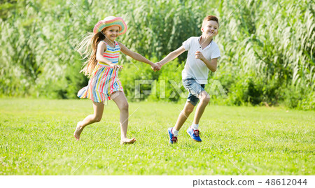 two happy children active playing and running outdoors 48612044