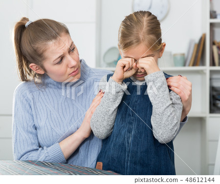 Mother comforts offended little daughter at home Mother comforts offended little daughter at home 48612144