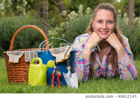 female with gardening tools while lying in park female with gardening tools while lying in park 48612145