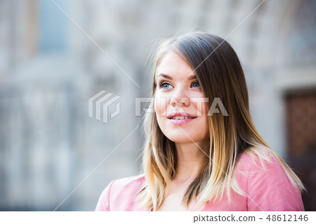 Close up of young woman standing at the street among architecture Close up of young woman standing at the street among architecture 48612146