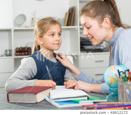Woman helping her daughter Woman helping her daughter 48612272