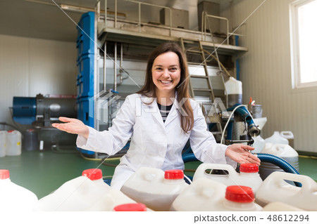 girl filling bottles with olive oil girl filling bottles with olive oil 48612294