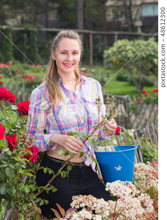 young woman holding a basket and standing in the park of roses young woman holding a basket and standing in the park of roses 48612300